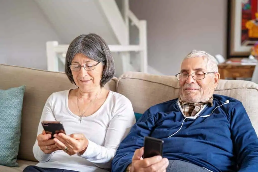 Modern-senior-lifestyle-old-couple-sitting-together-on-sofa-at-home-smiling-looking-at-their_t20_G01EPo