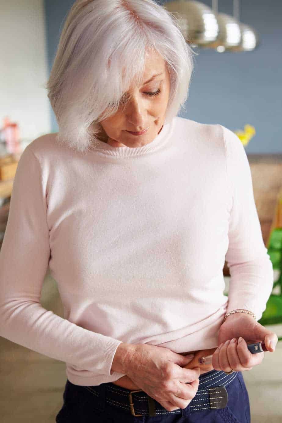 senior female diabetic injecting themselves with i PD75FYB 2 1
